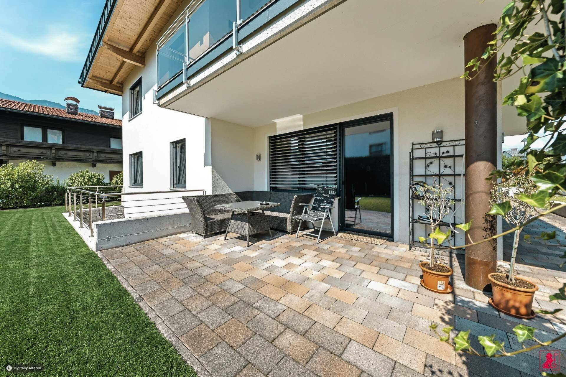Gemütliche gepflasterte Terrasse mit Gartenmöbeln und Zugang zum Haus.