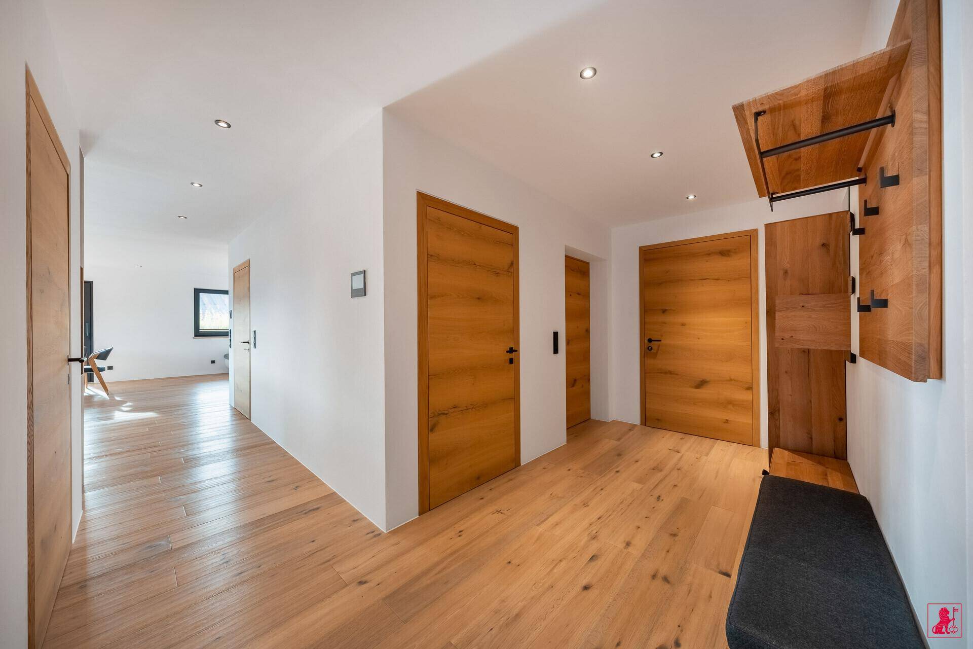 Heller Flur mit Holztüren, Garderobe und Einbauschränken.