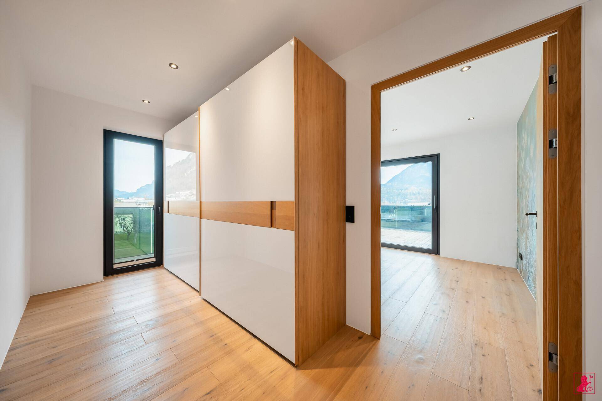 Schlafzimmer mit modernen Einbauschränken und Zugang zu einem Balkon oder Terrasse.