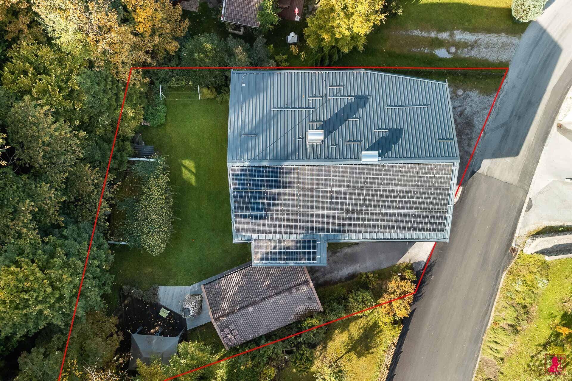 Dachansicht des Hauses mit Photovoltaikanlage und großem Gartenbereich.