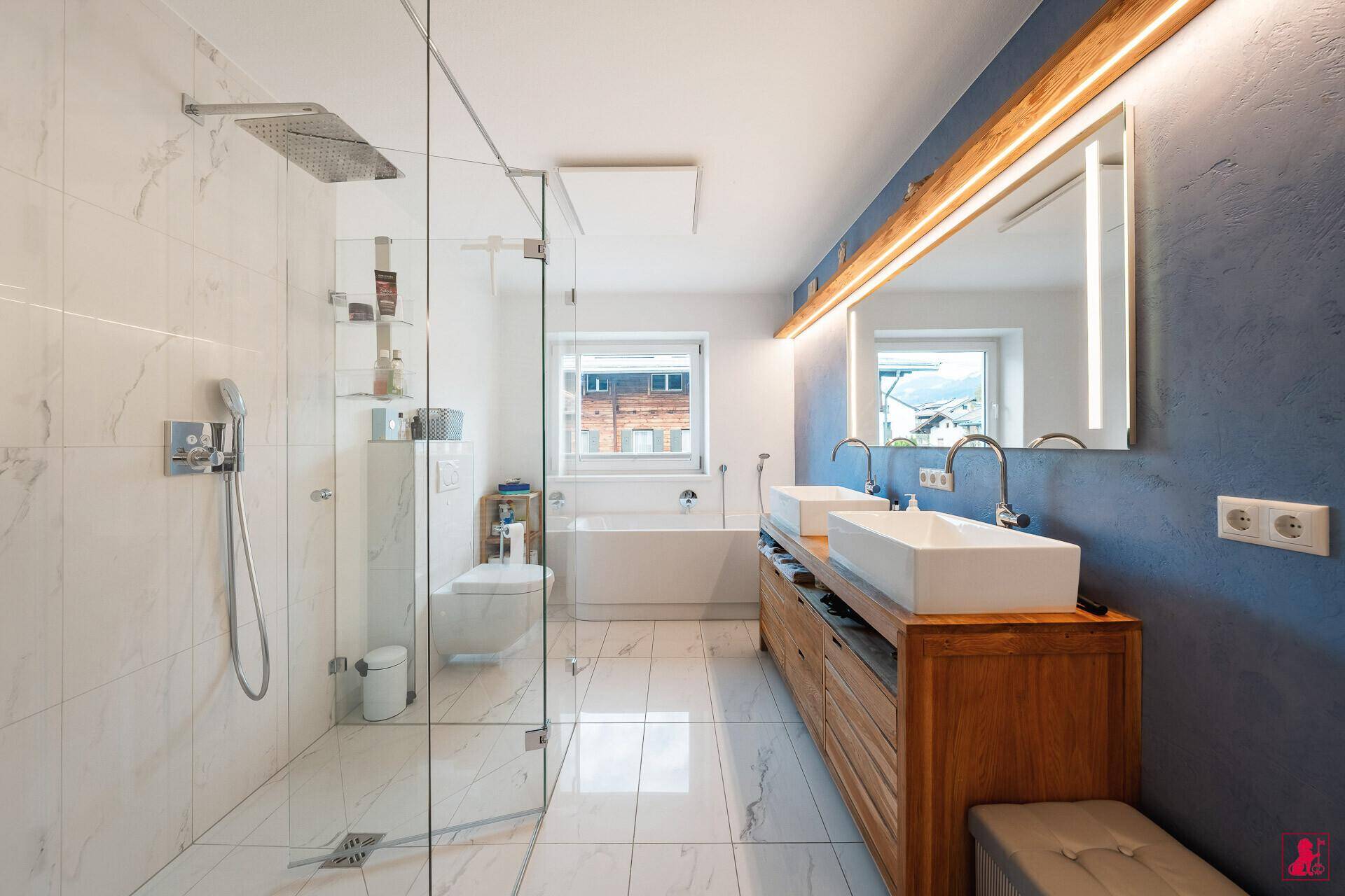 Elegantes Badezimmer mit Doppelwaschbecken, Badewanne und geräumiger Glasdusche.