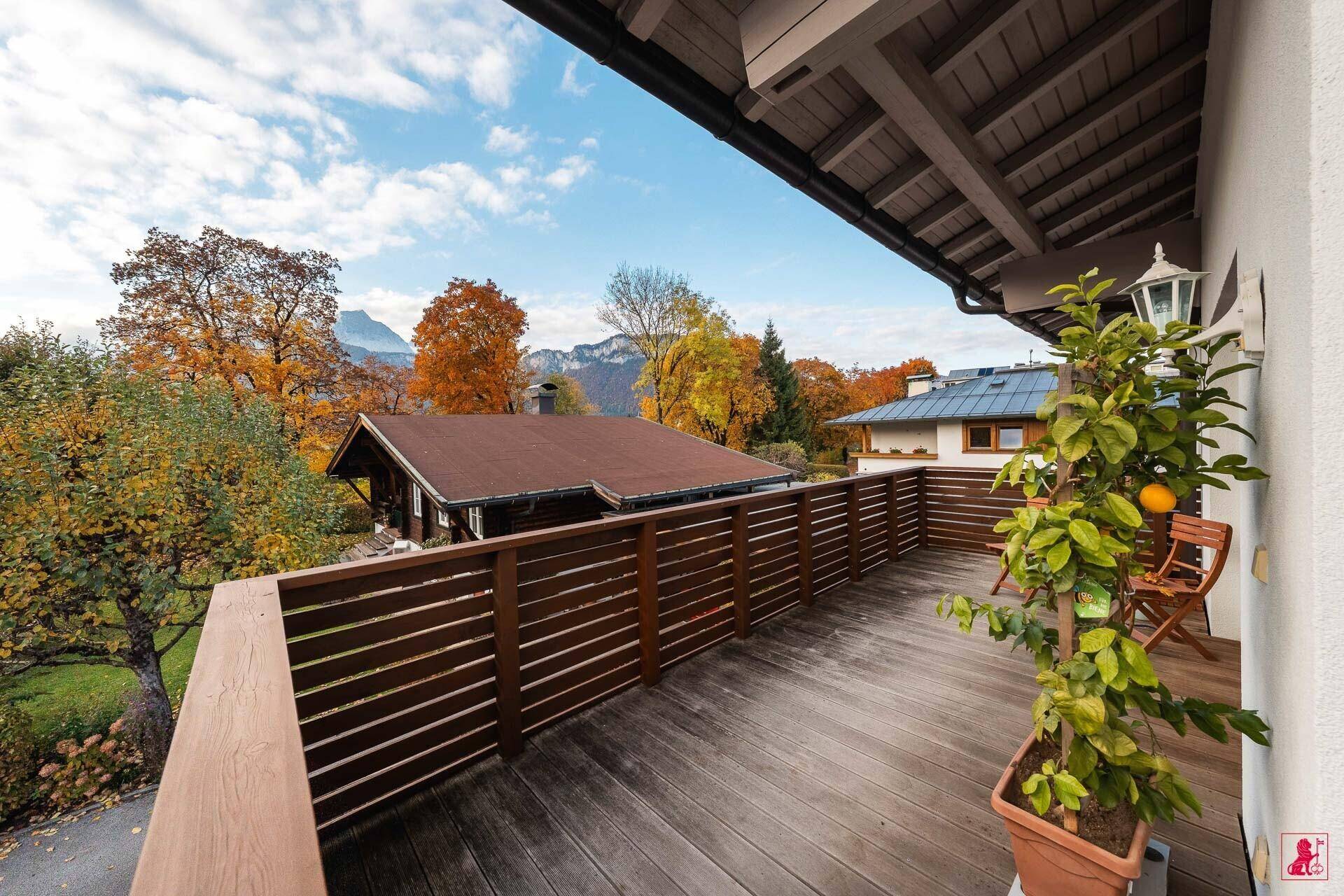 Geräumiger Holzbalkon mit Topfpflanze und weitem Blick auf die herbstliche Landschaft.