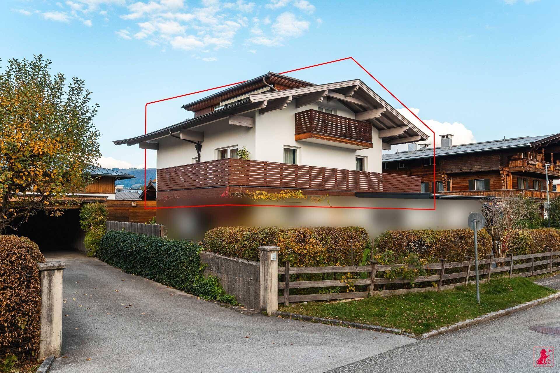 Ansicht des Hauses mit moderner Architektur, Balkonen und gepflegter Außenanlage in ländlicher Umgebung.