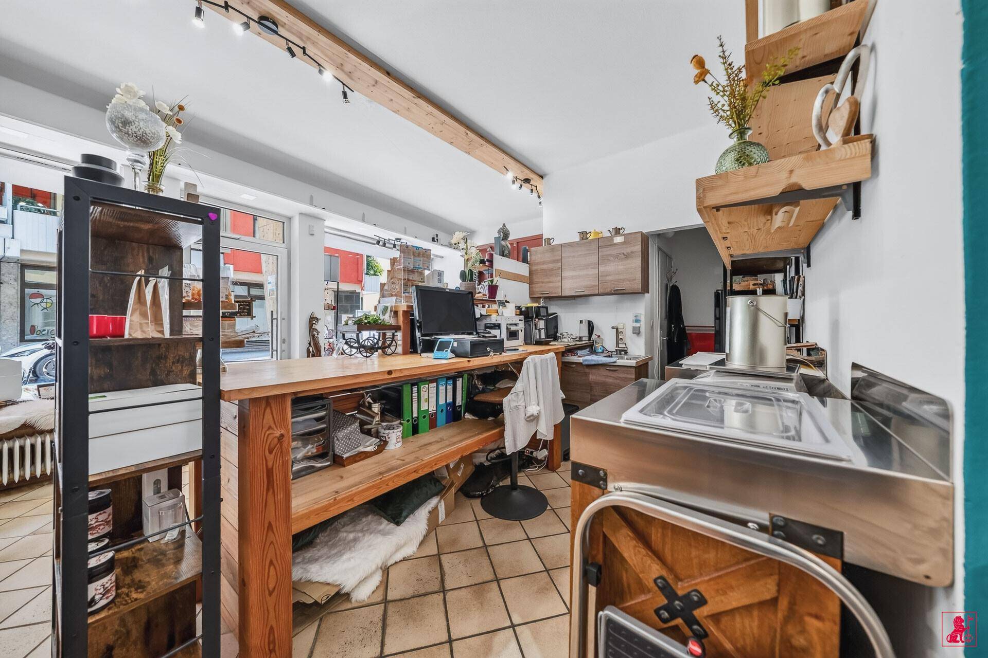 Funktionaler Bereich mit Spülbecken, Arbeitsplatte und Stauraum im hinteren Teil des Geschäfts.
