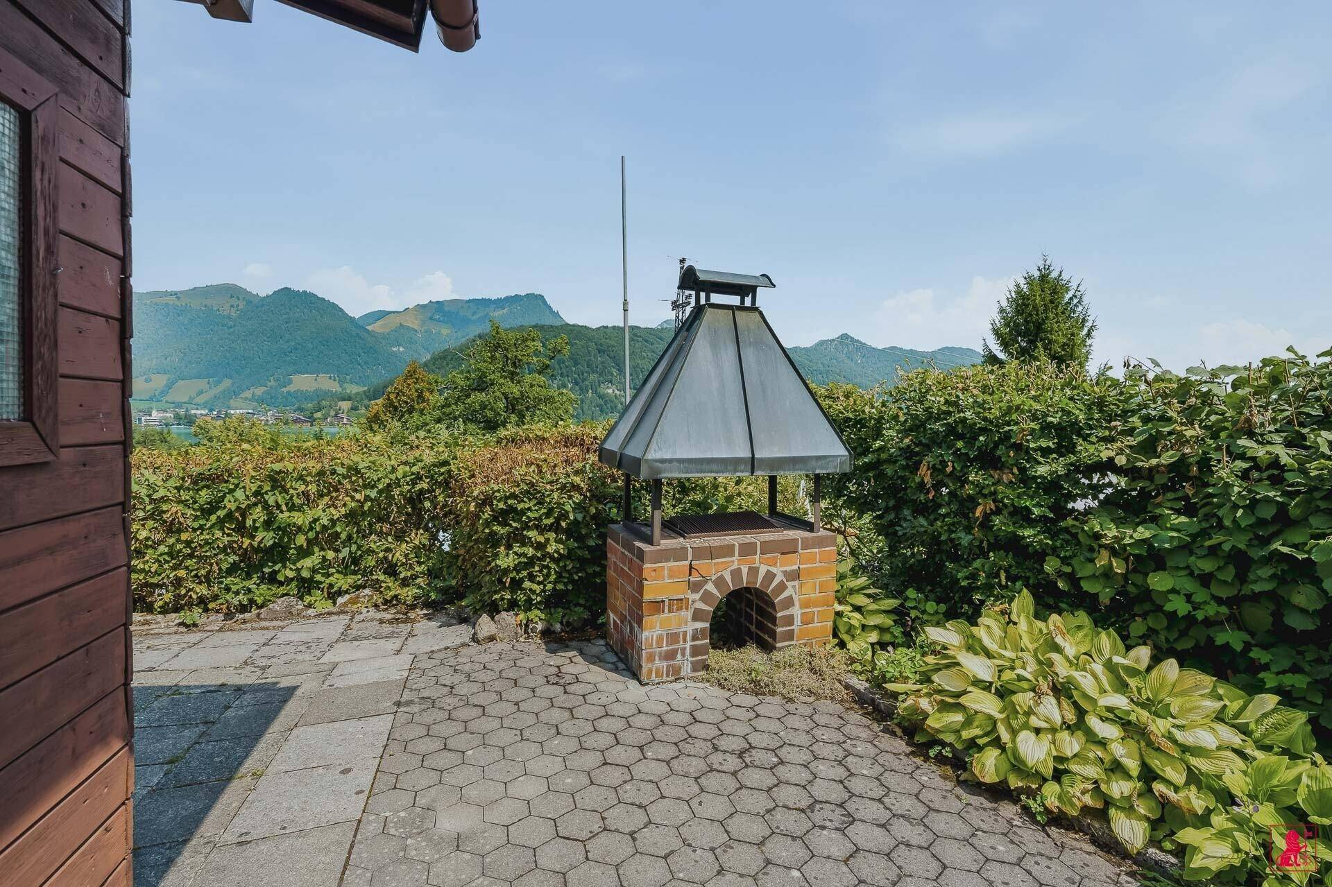 Gemauerter Grill auf der Terrasse mit schöner Aussicht auf die umliegende Berglandschaft.