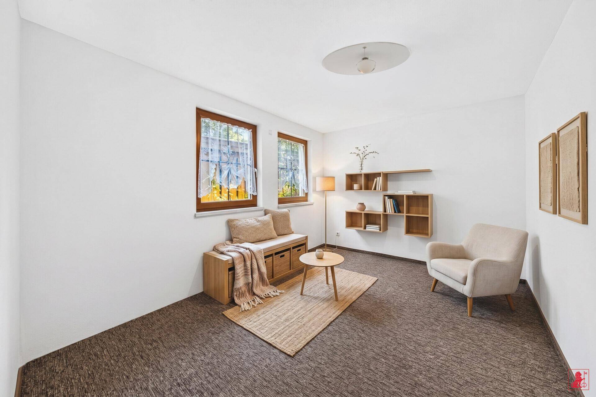 Gemütlicher Raum mit Teppichboden, Sitzgelegenheiten und Wandregalen für persönliche Gegenstände.