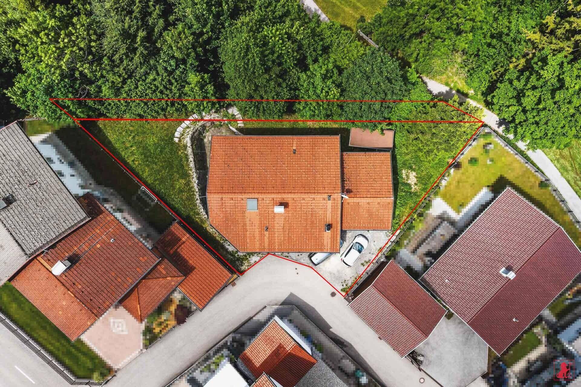 Vogelperspektive des Grundstücks mit dem Haus und der rot markierten Parzelle.