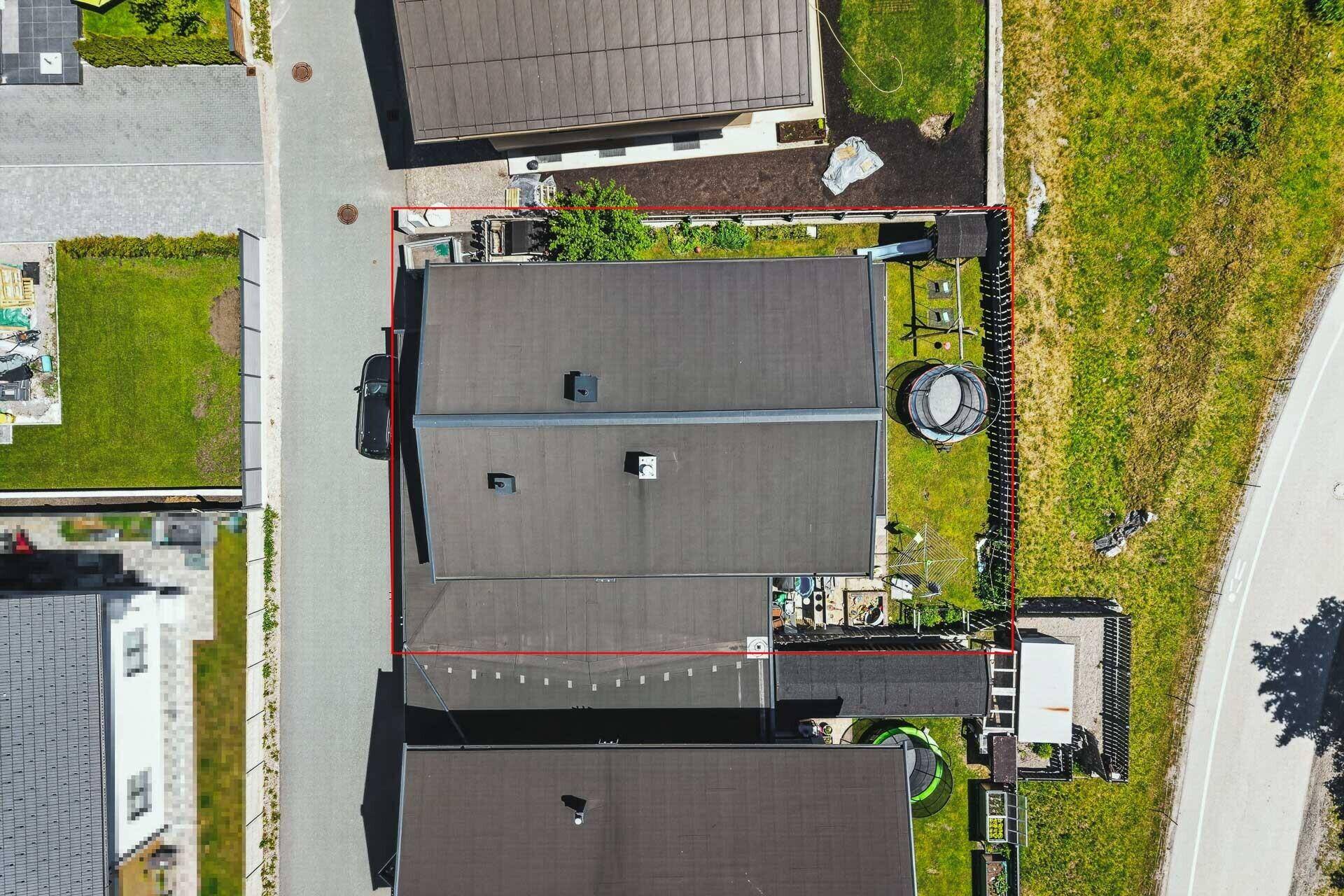 Draufsicht auf das Haus mit Dach, Garten und angrenzender Straße, umgeben von anderen Häusern.