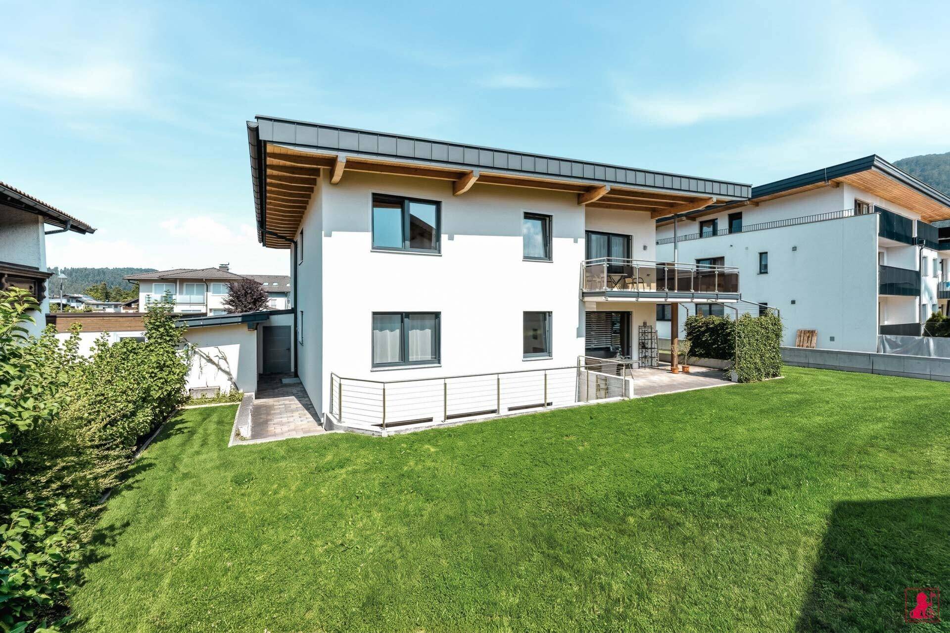 Seitenansicht des modernen Einfamilienhauses mit Garten und Zugang zum Untergeschoss.