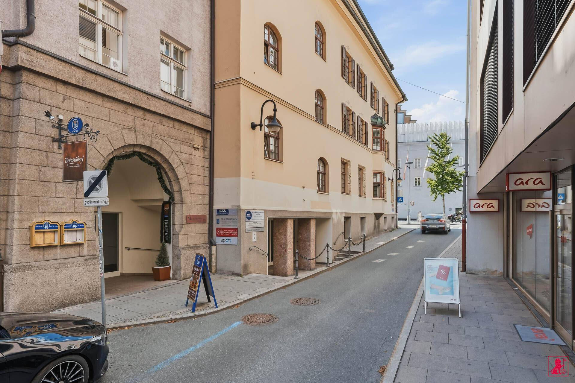 Eine belebte Straße mit historischen Gebäuden und Geschäften, die das Stadtbild prägen.