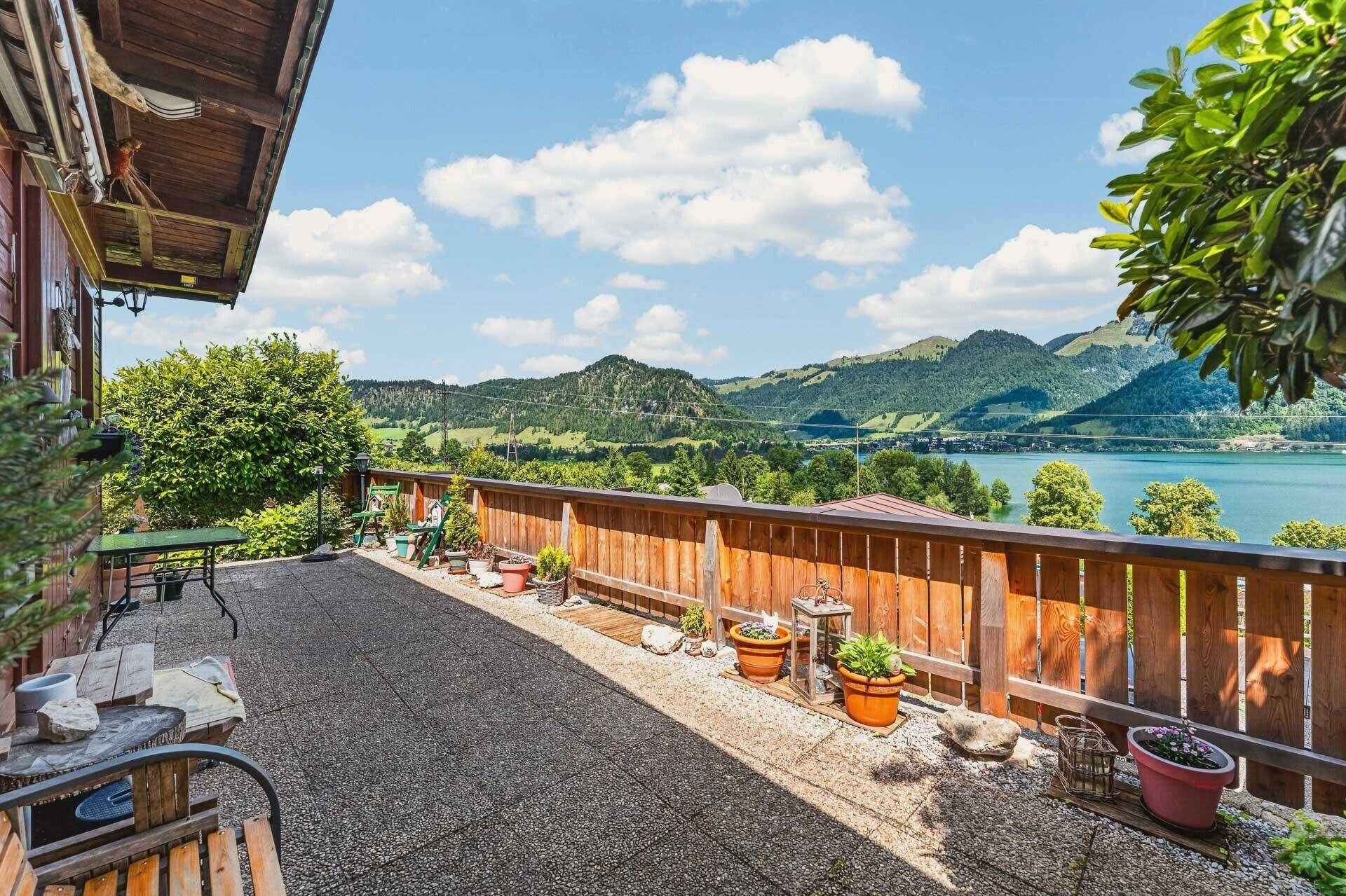 Geräumige Terrasse mit Holzzaun und atemberaubendem Blick auf den See und die Berge.