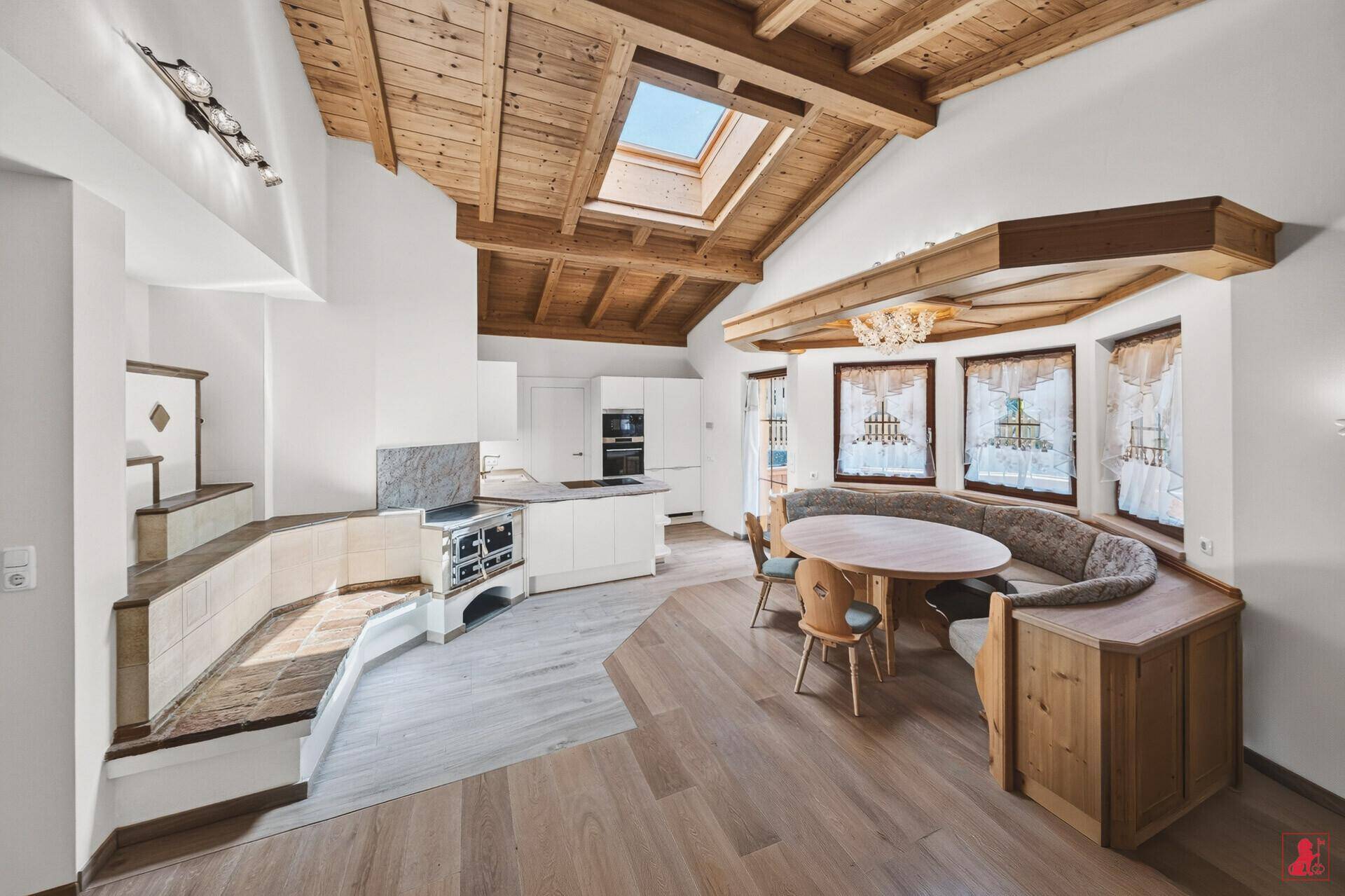Offener Wohn-Essbereich mit Holzbalkendecke, Dachfenster und traditioneller Essecke.