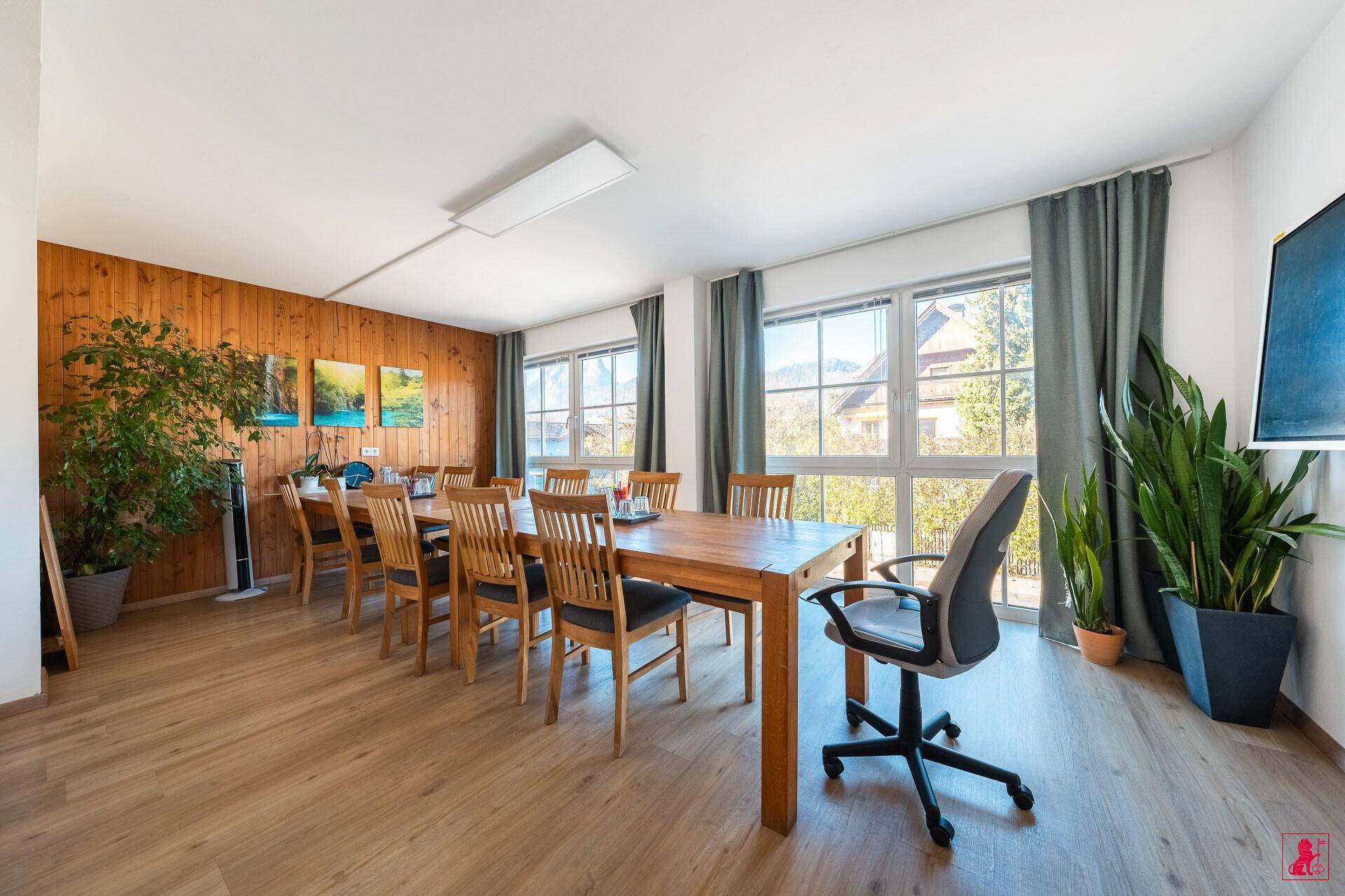 Großer Konferenzraum mit langem Holztisch, vielen Stühlen und weitem Blick auf die Berge.