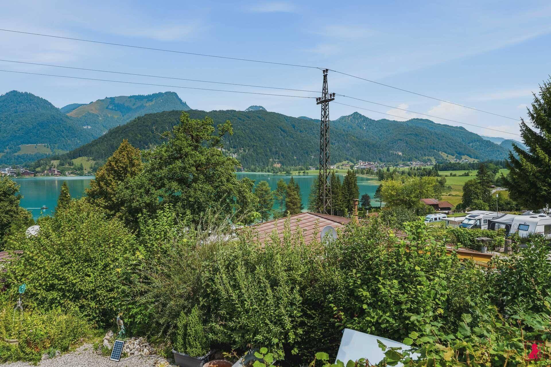 Panoramablick über die grüne Umgebung zum See und den majestätischen Bergen.