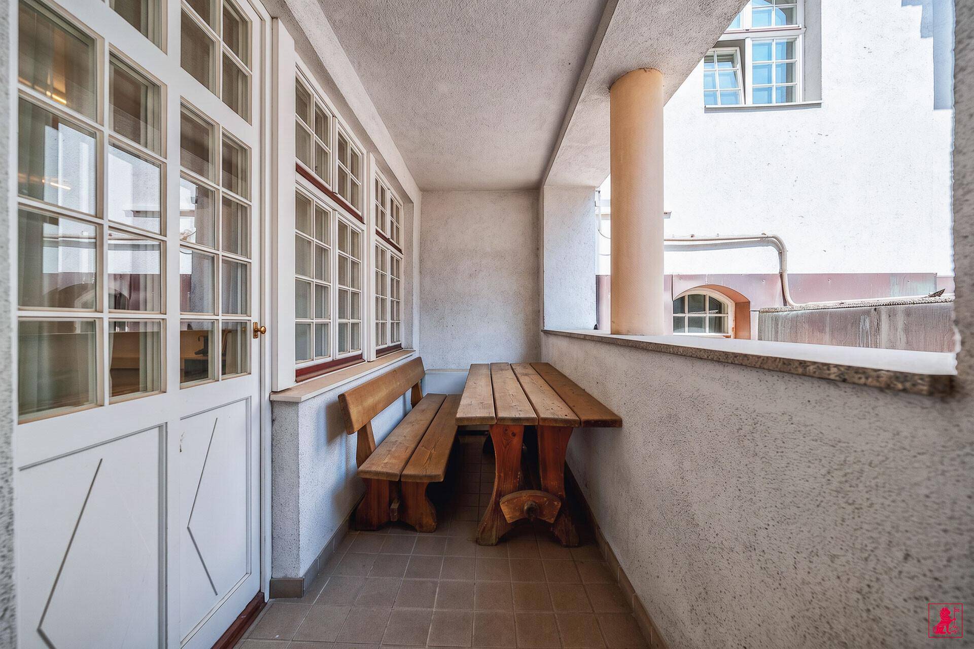 Überdachter Außenbereich mit rustikalen Holzmöbeln, ideal für entspannte Stunden im Freien.