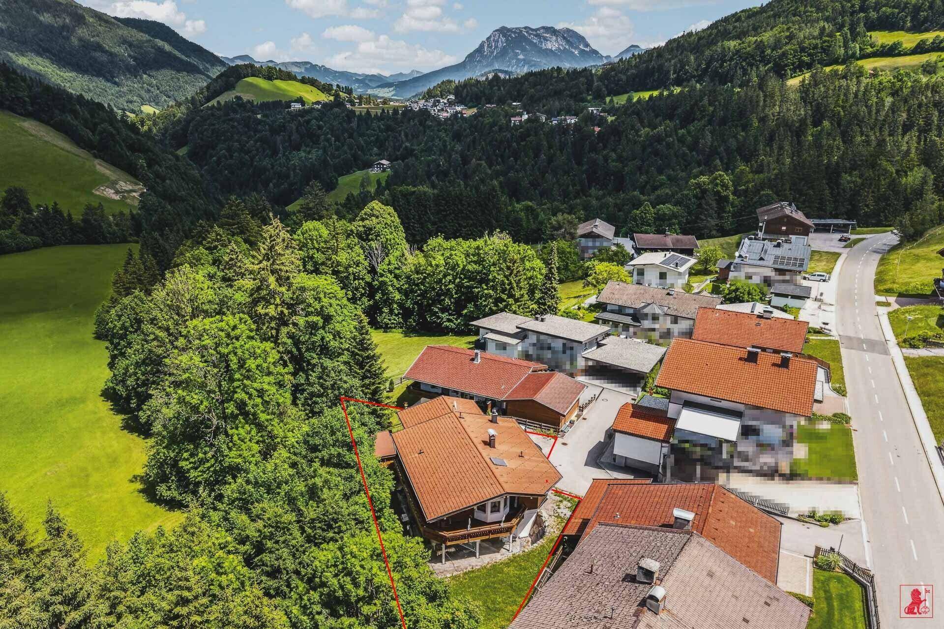 Luftaufnahme des Anwesens in einer grünen Umgebung mit Bergen im Hintergrund.