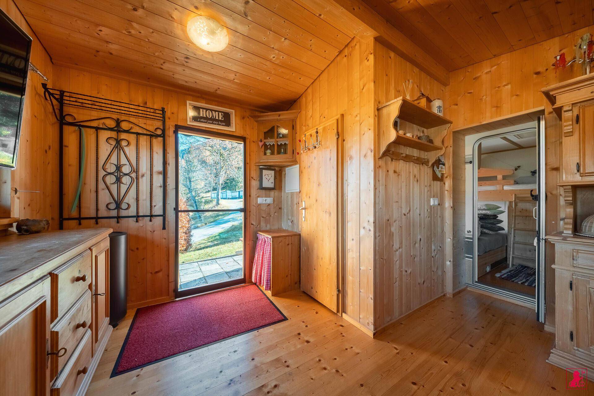 Heller Eingangsbereich mit Holzvertäfelung, Garderobe und Zugang zu weiteren Räumen.