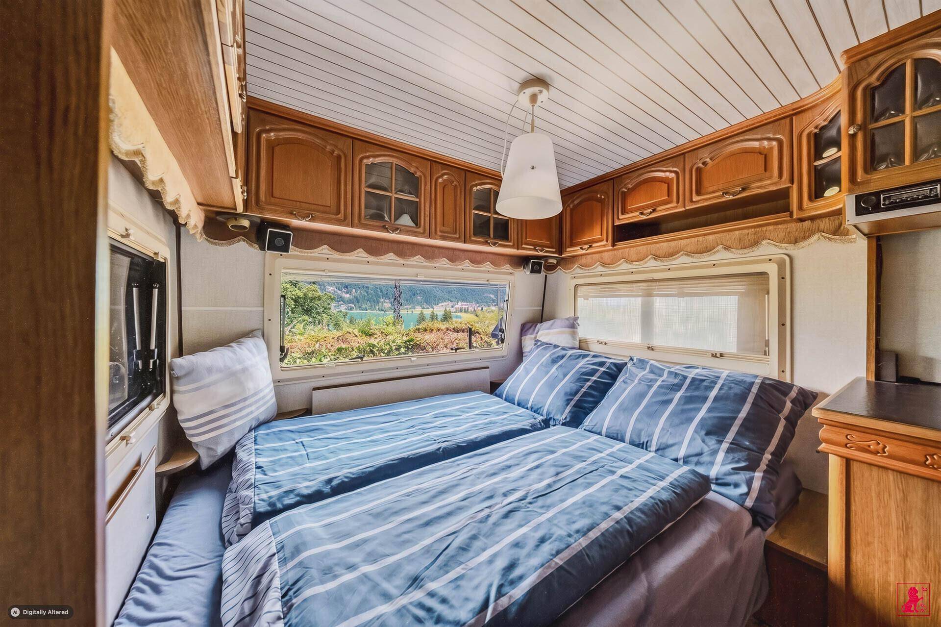 Schlafzimmer mit Doppelbett und Panoramablick auf den See und die Berge.