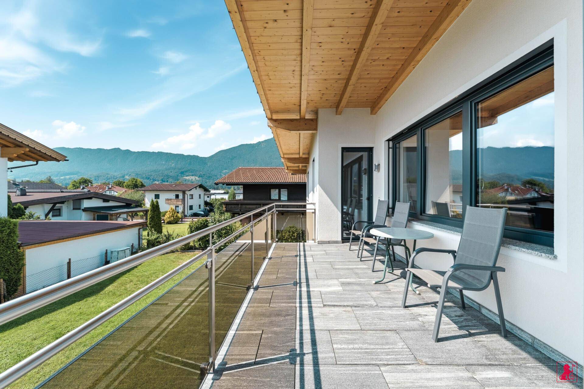 Geräumiger Balkon mit Sitzgelegenheiten, Fliesenboden und weitem Bergblick.