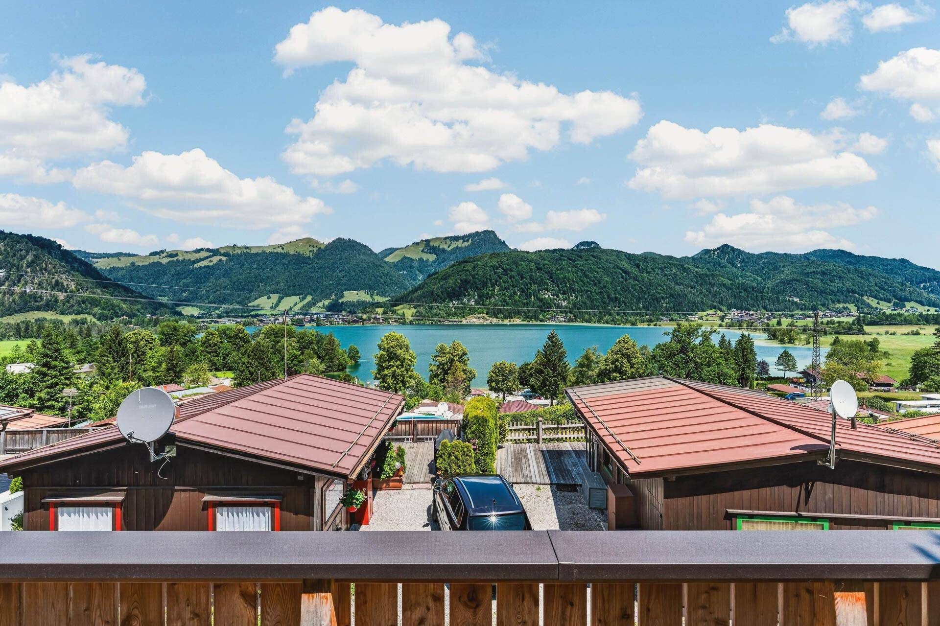 Panoramablick auf den See und die umliegenden Berge von der Unterkunft aus, mit weiteren Häusern.