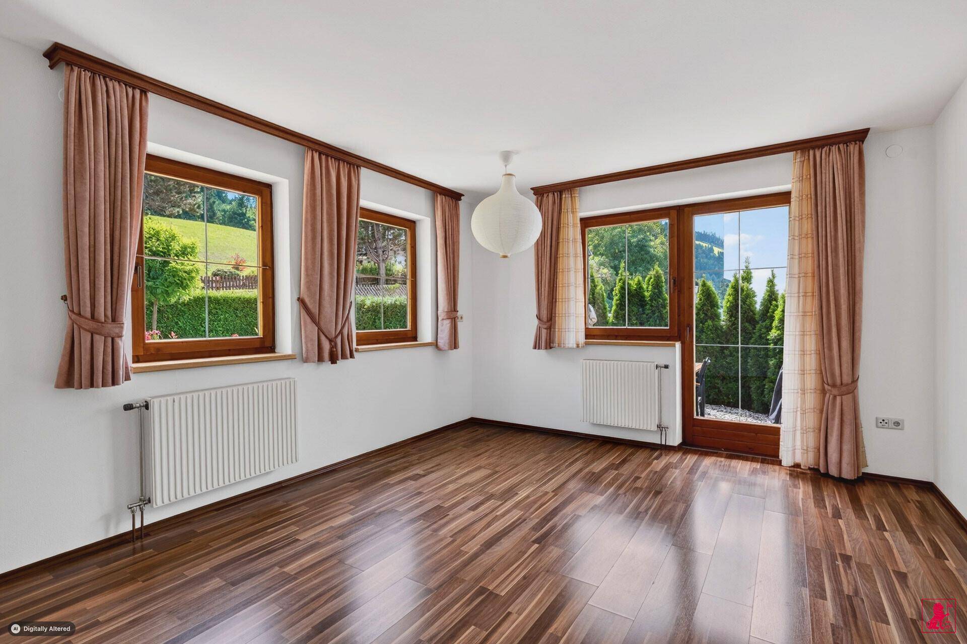 Geräumiges Zimmer mit Laminatboden, großen Fenstern und Zugang zum Außenbereich.