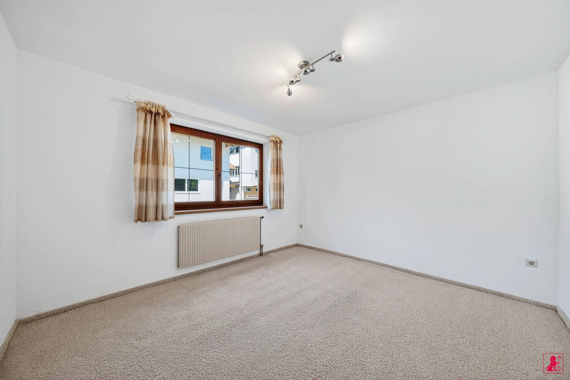 Schlafzimmer mit Teppichboden, Fenster und Blick auf die Nachbarschaft.