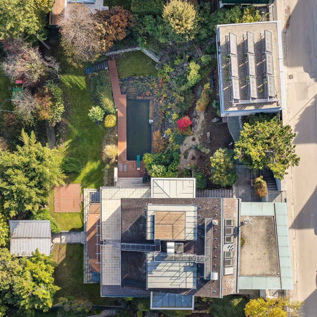 Draufsicht des Anwesens mit Flachdächern, Solaranlagen und einem weitläufigen Gartenbereich.