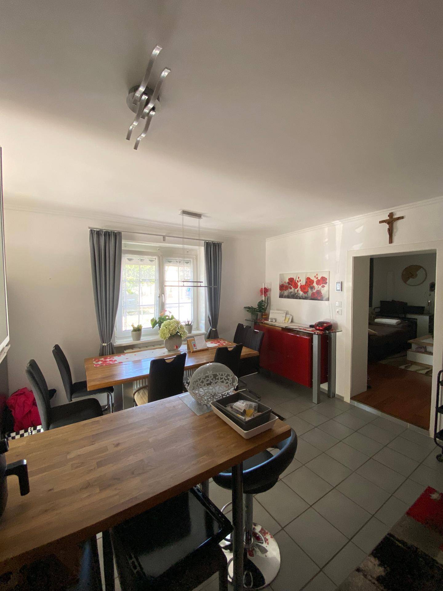 Heller Essbereich in der Küche mit großem Fenster und Holztisch.