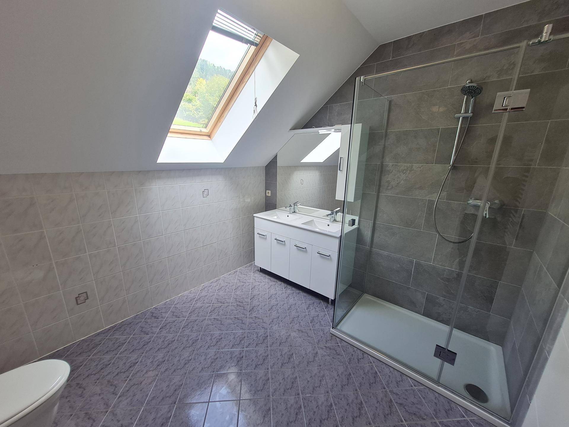 Modernes Badezimmer im Dachgeschoss mit Schrägdach, Dachfenster, Doppelwaschbecken und Duschkabine.
