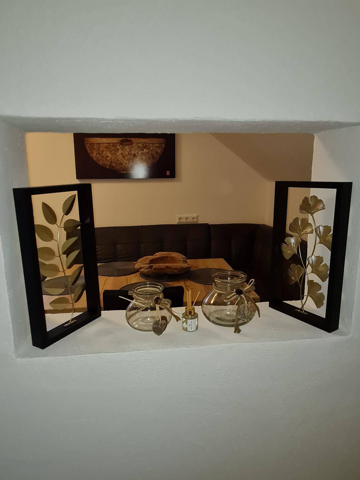 Blick durch eine Wandöffnung auf einen gemütlichen Essbereich mit Eckbank und Holztisch.