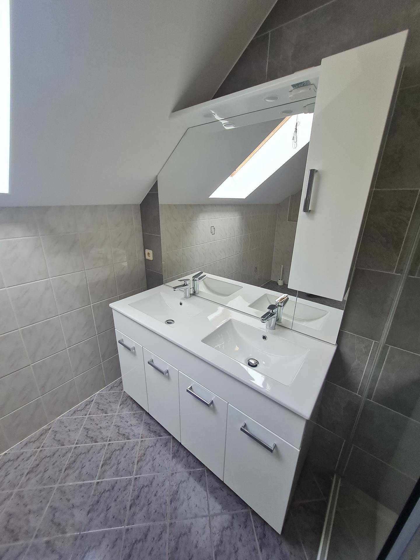 Doppelwaschbecken mit großem Spiegel und Spiegelschrank in einem modernen Badezimmer.