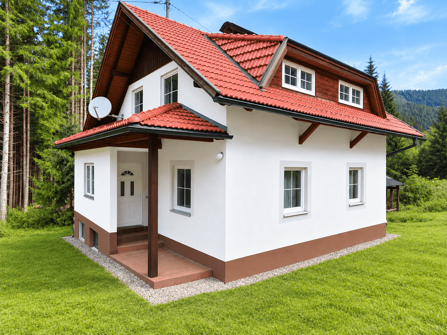 Charmantes Haus mit weißer Fassade und rotem Ziegeldach, umgeben von grünem Rasen und Bäumen.