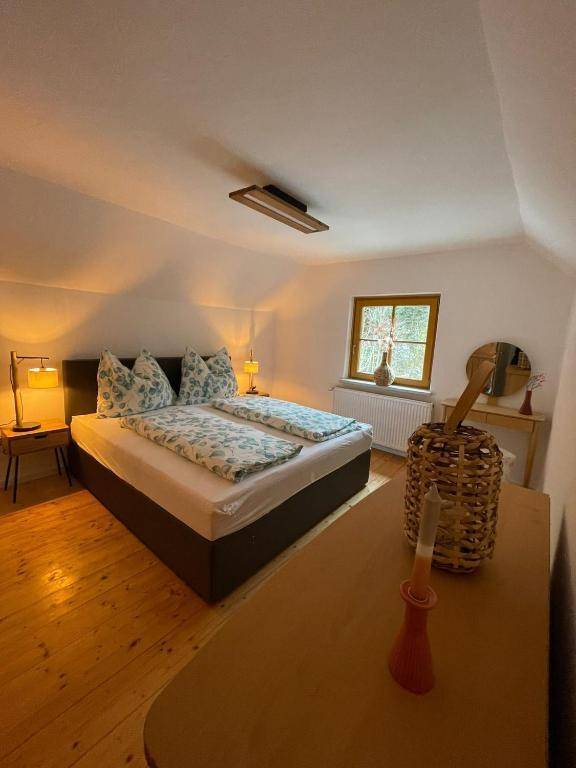 Helles Schlafzimmer mit Doppelbett, Holzboden, Fenster und Nachttischen mit stimmungsvollen Lampen.
