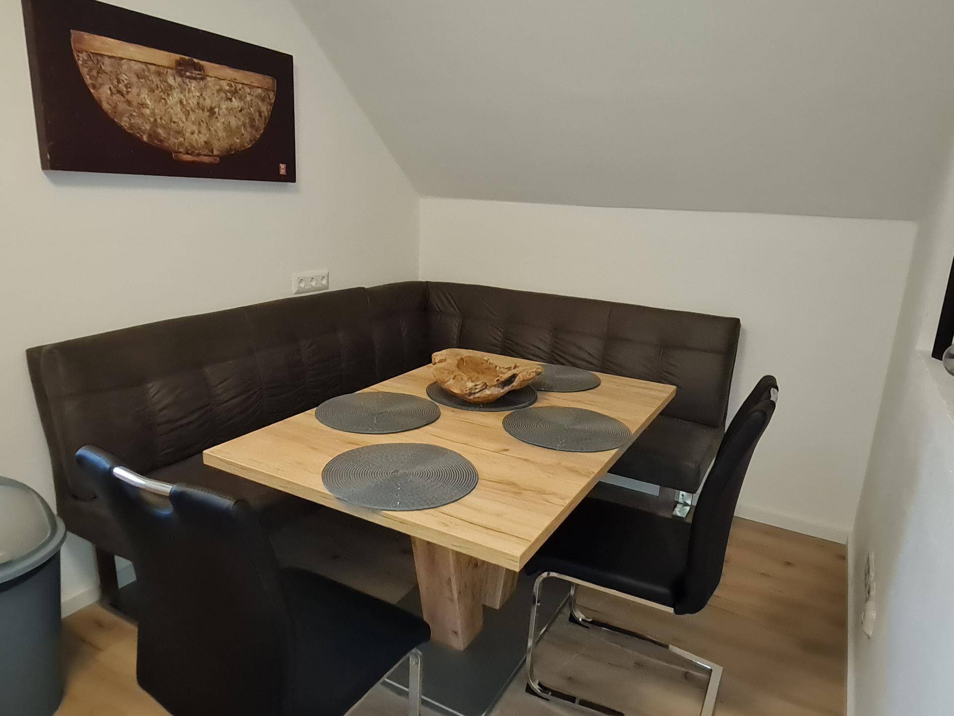 Gemütlicher Essbereich mit Eckbank, Holztisch und Dachschräge in einem modernen Ambiente.