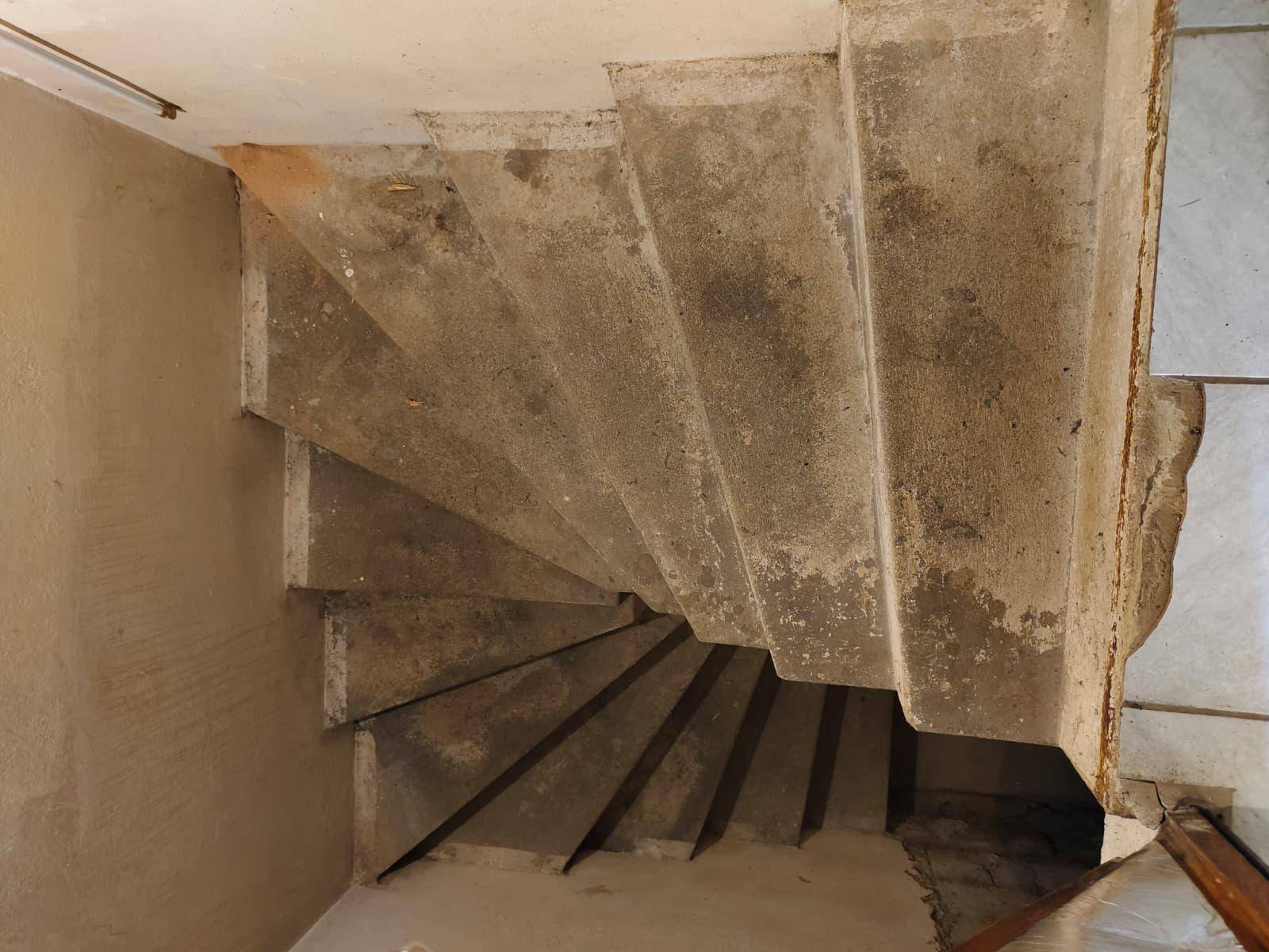 Eine schlichte Betontreppe in Spiralform führt in die unteren Etagen des Hauses.
