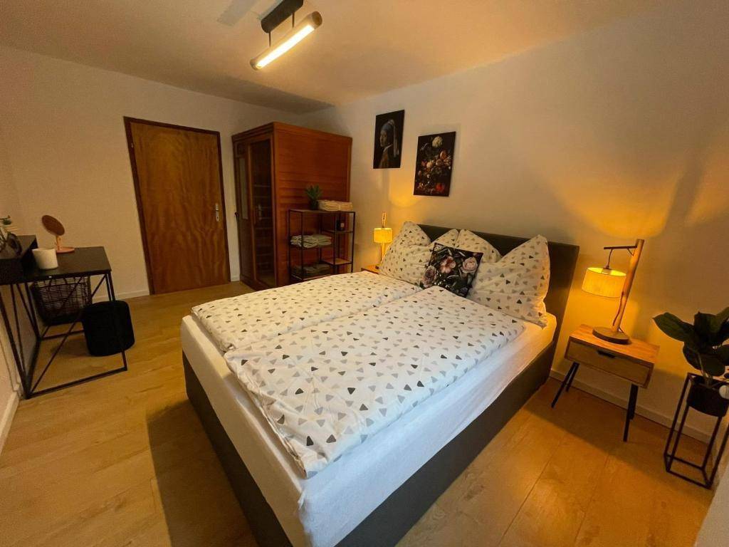 Schlafzimmer mit Doppelbett, Holzboden, Kleiderschrank und Nachttischen mit Lampen für gemütliche Atmosphäre.