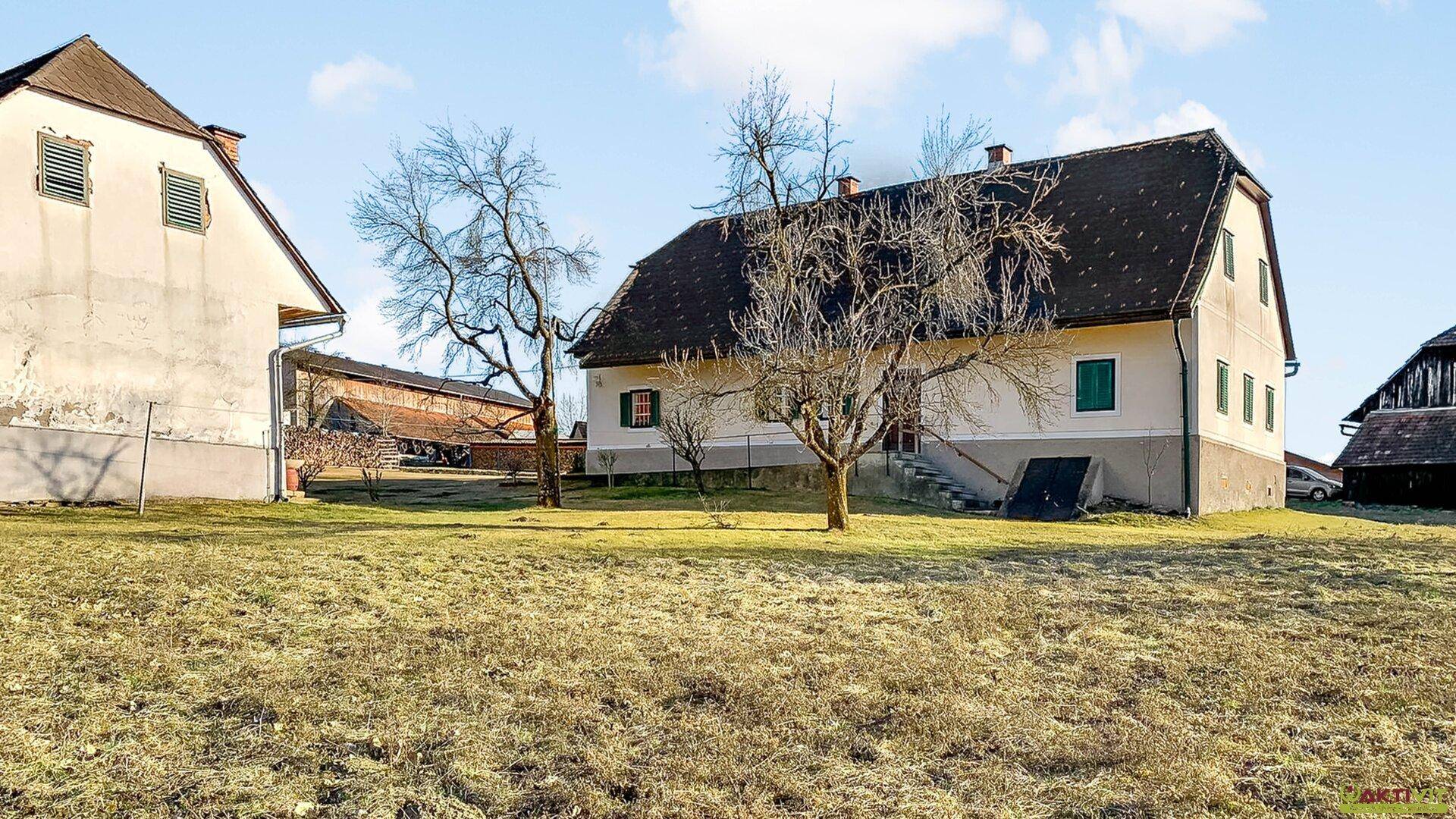 Weitläufiges Grundstück mit mehreren Gebäuden und offener Landschaft unter sonnigem Himmel.