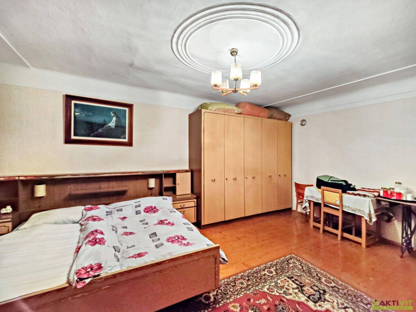 Geräumiges Schlafzimmer mit Doppelbett, großem Kleiderschrank und traditionellem Teppich.
