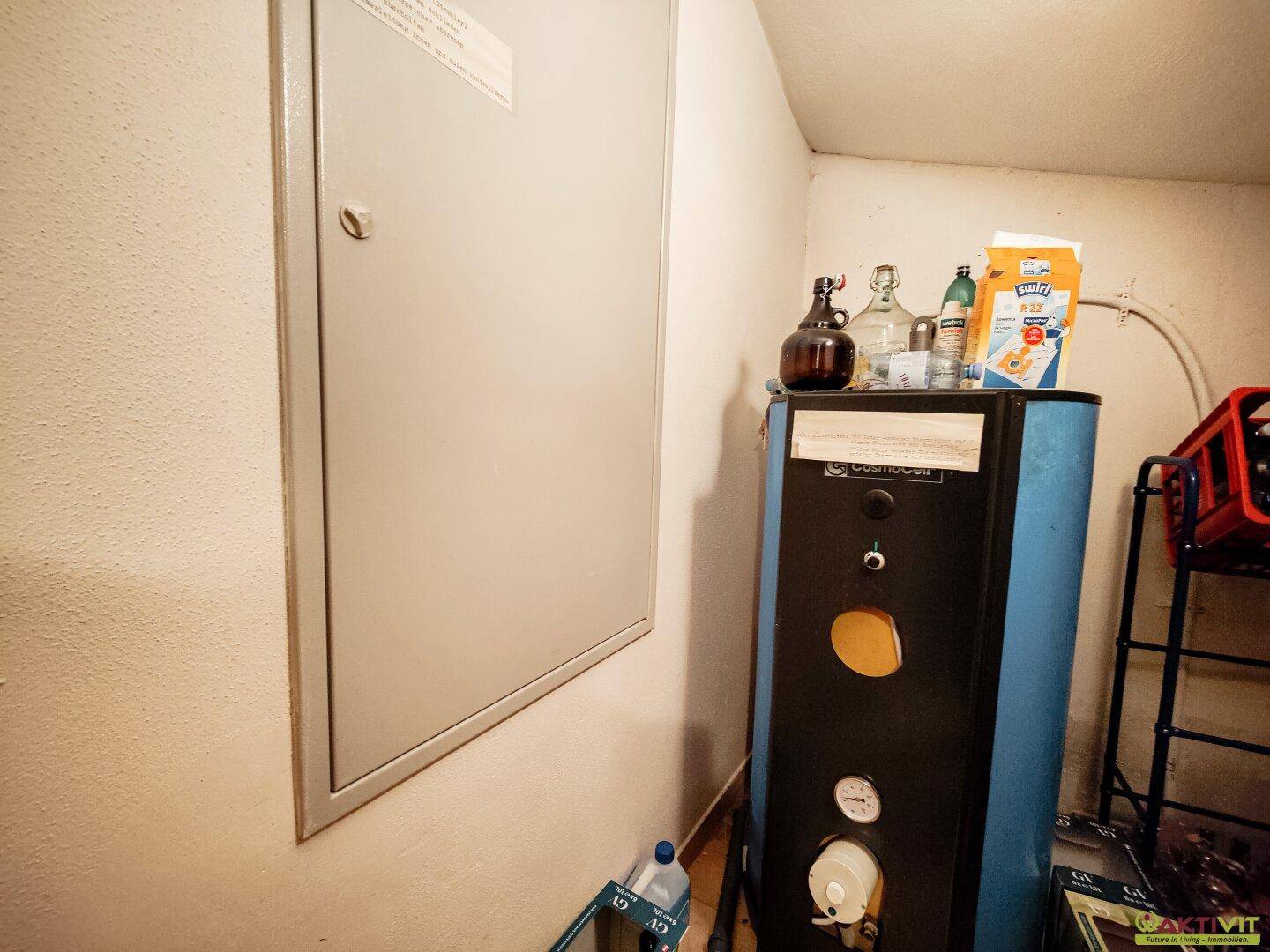 Hauswirtschaftsraum mit Warmwasserboiler und Stauraum.