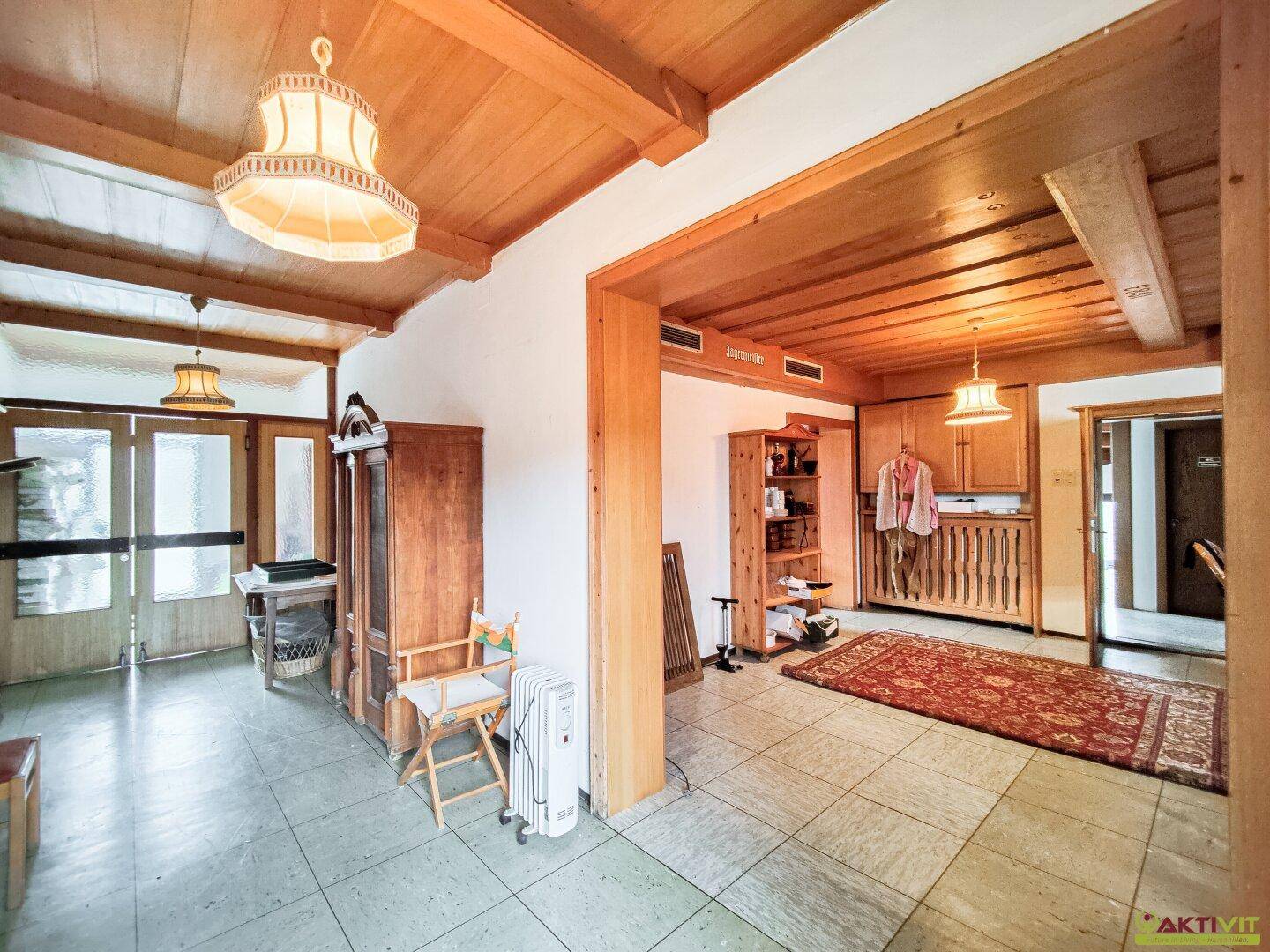 Geräumiger Flur mit Holzdecken, Fliesenboden und traditioneller Einrichtung.