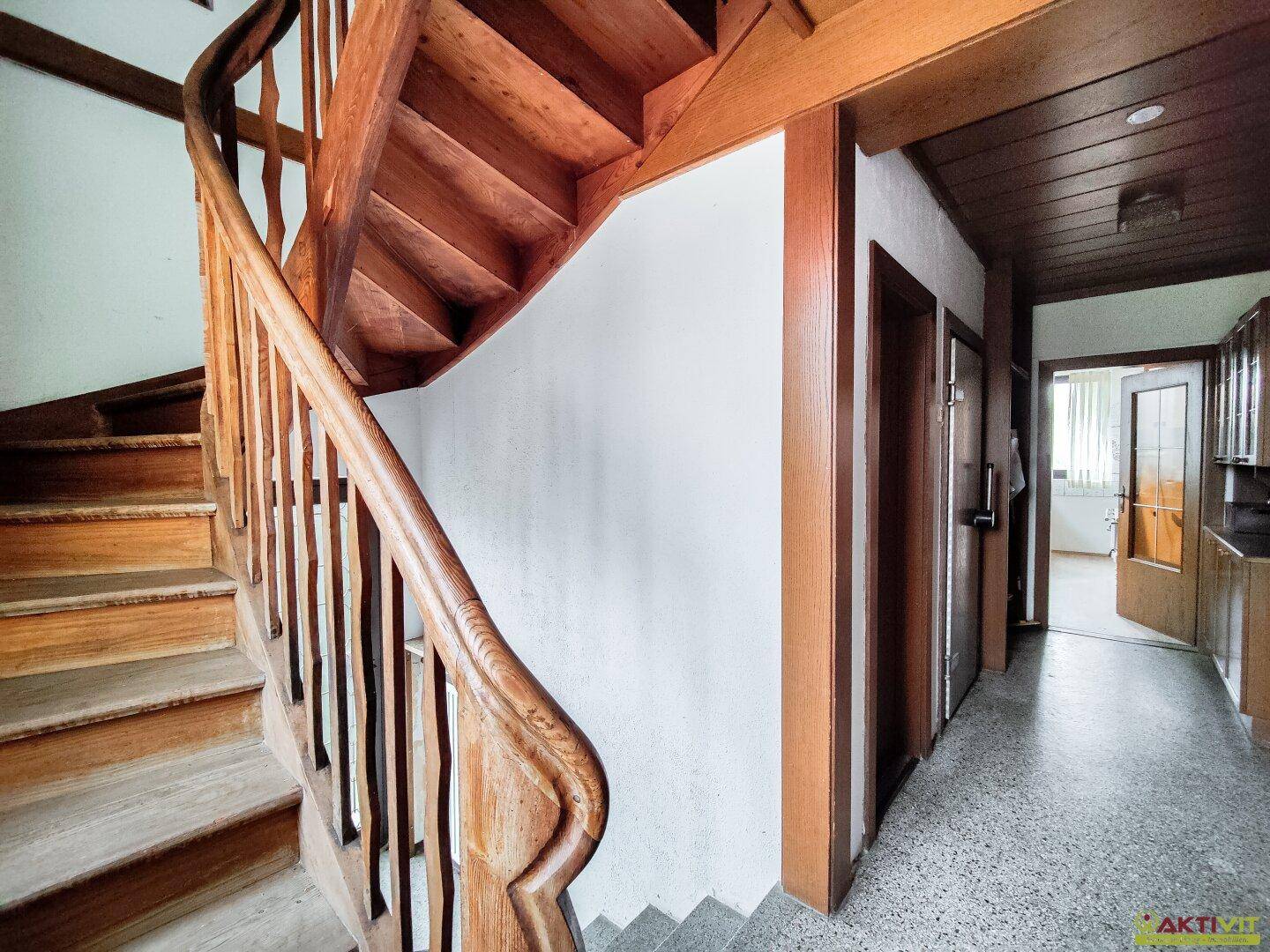 Geschwungene Holztreppe führt in die oberen Etagen des Hauses.