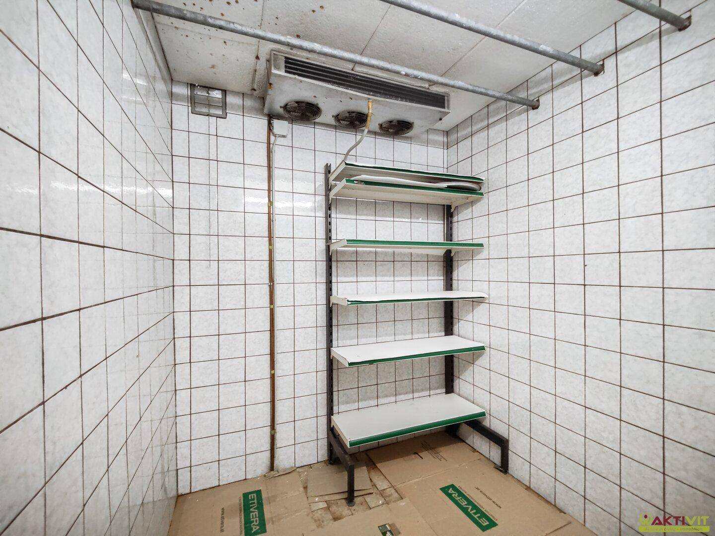 Gekühlter Abstellraum mit Fliesenwänden und Regalsystem.