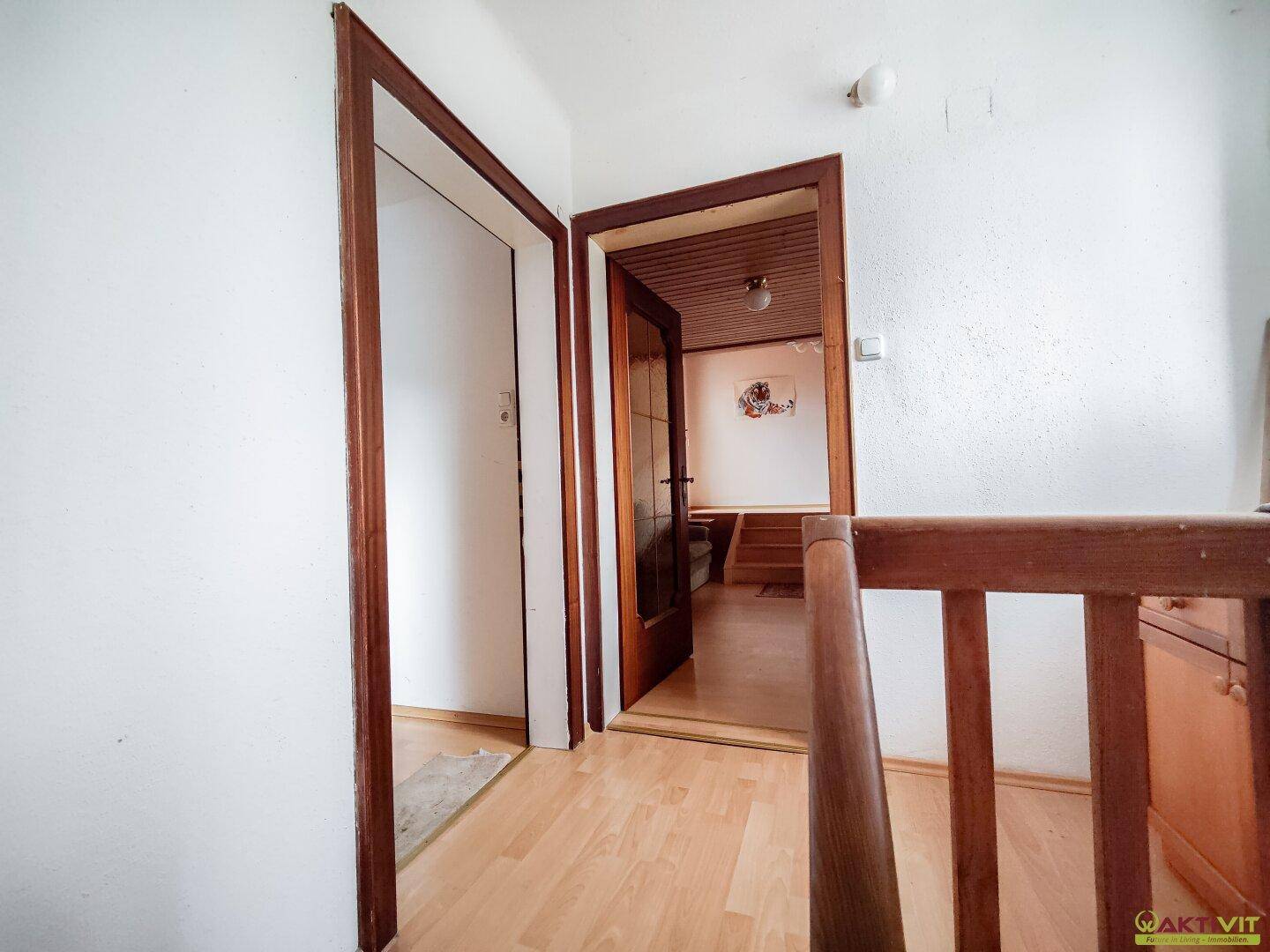Heller Flur mit Holzboden und Zugang zu weiteren Räumen.