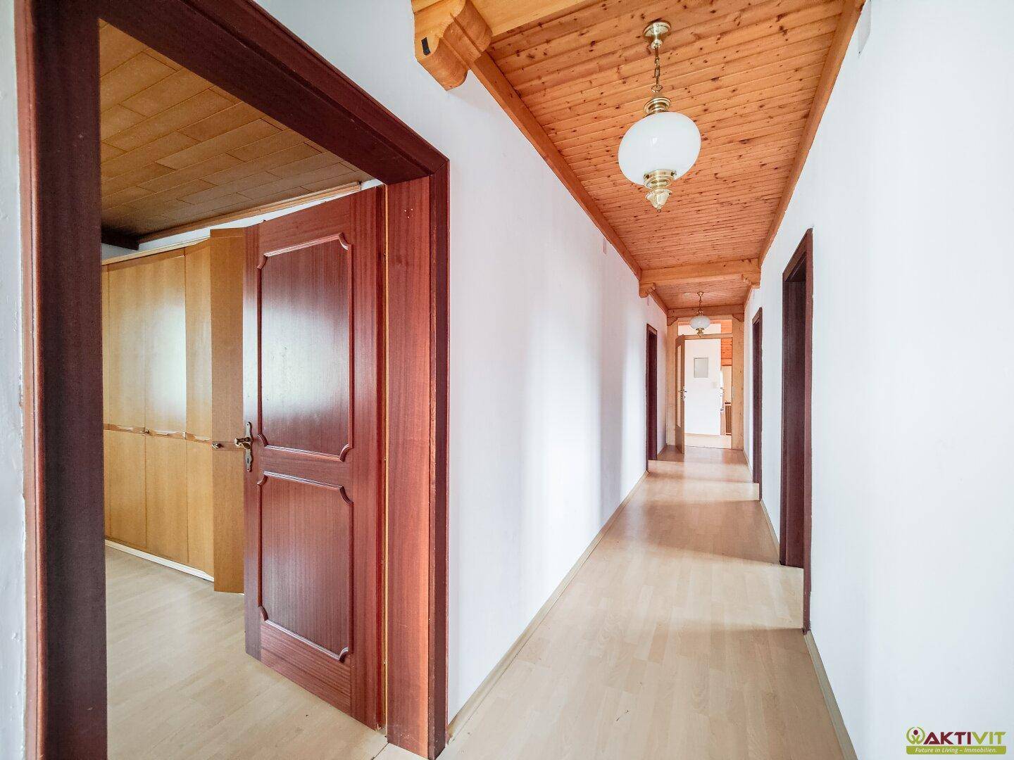 Heller Flur mit Holzdecke und integrierten Holzschränken.