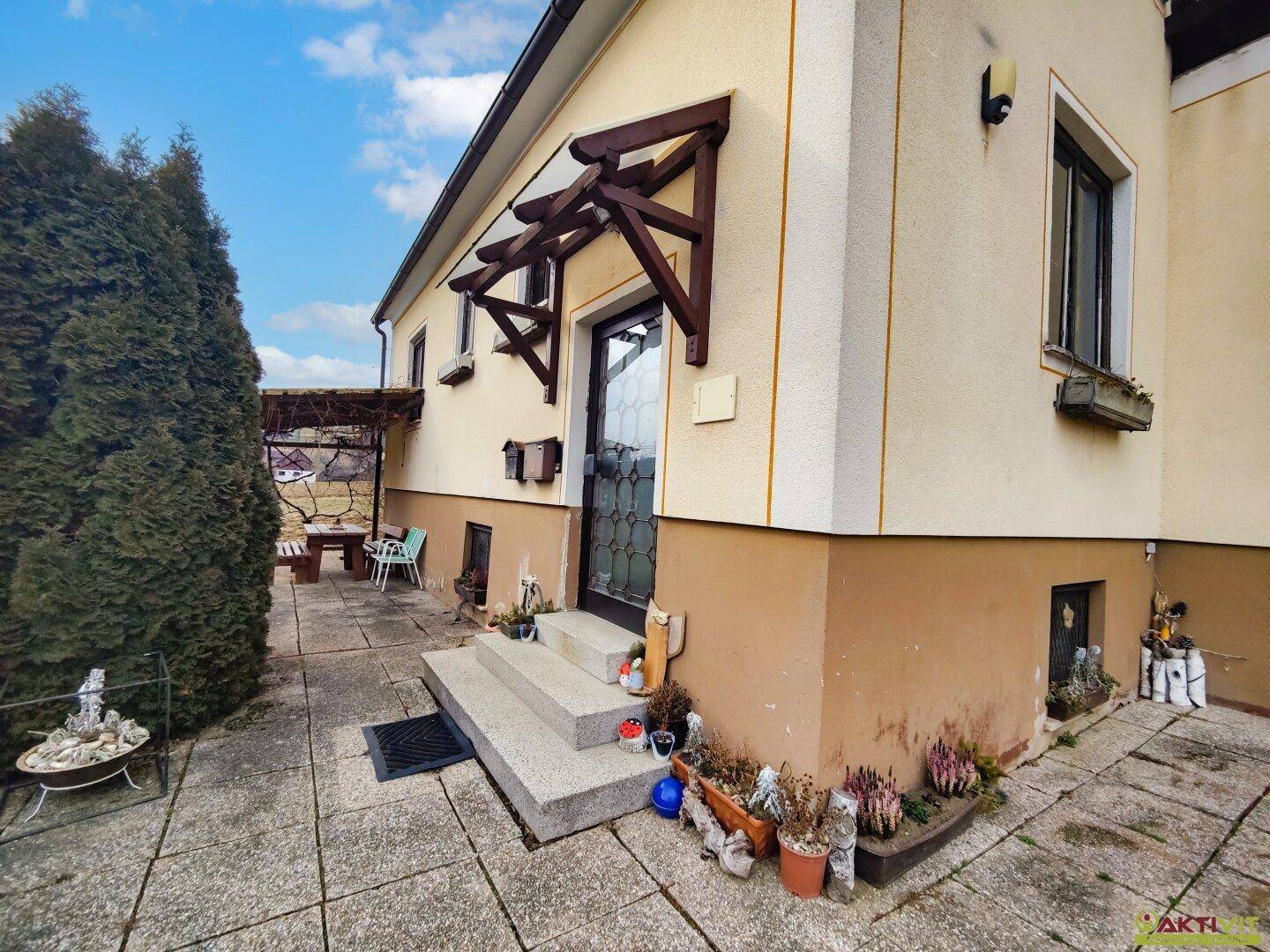 Eingangsbereich des Hauses mit Treppe und dekorativen Pflanzen.