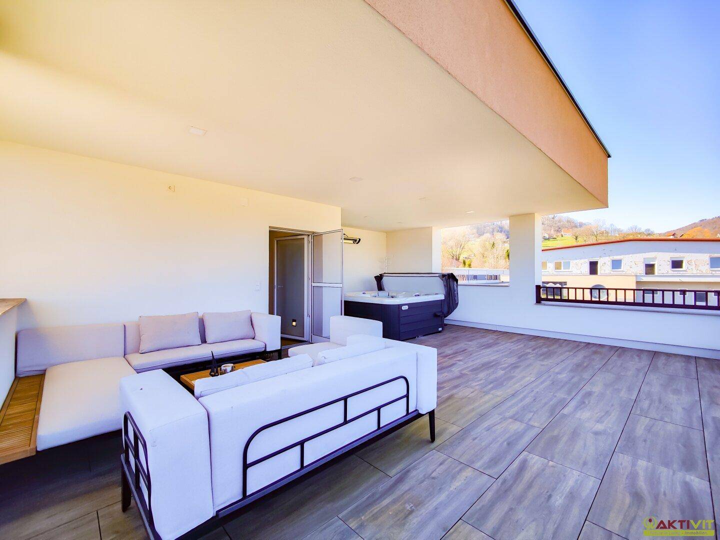 Großzügige Dachterrasse mit bequemen Loungemöbeln, Whirlpool und Blick ins Grüne.