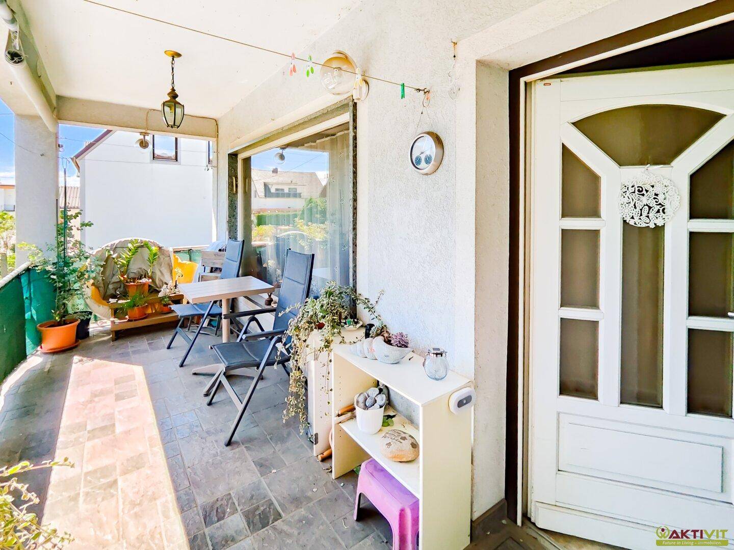 Gemütlicher Balkon mit Sitzgelegenheiten und Pflanzen, ideal für entspannte Stunden im Freien.