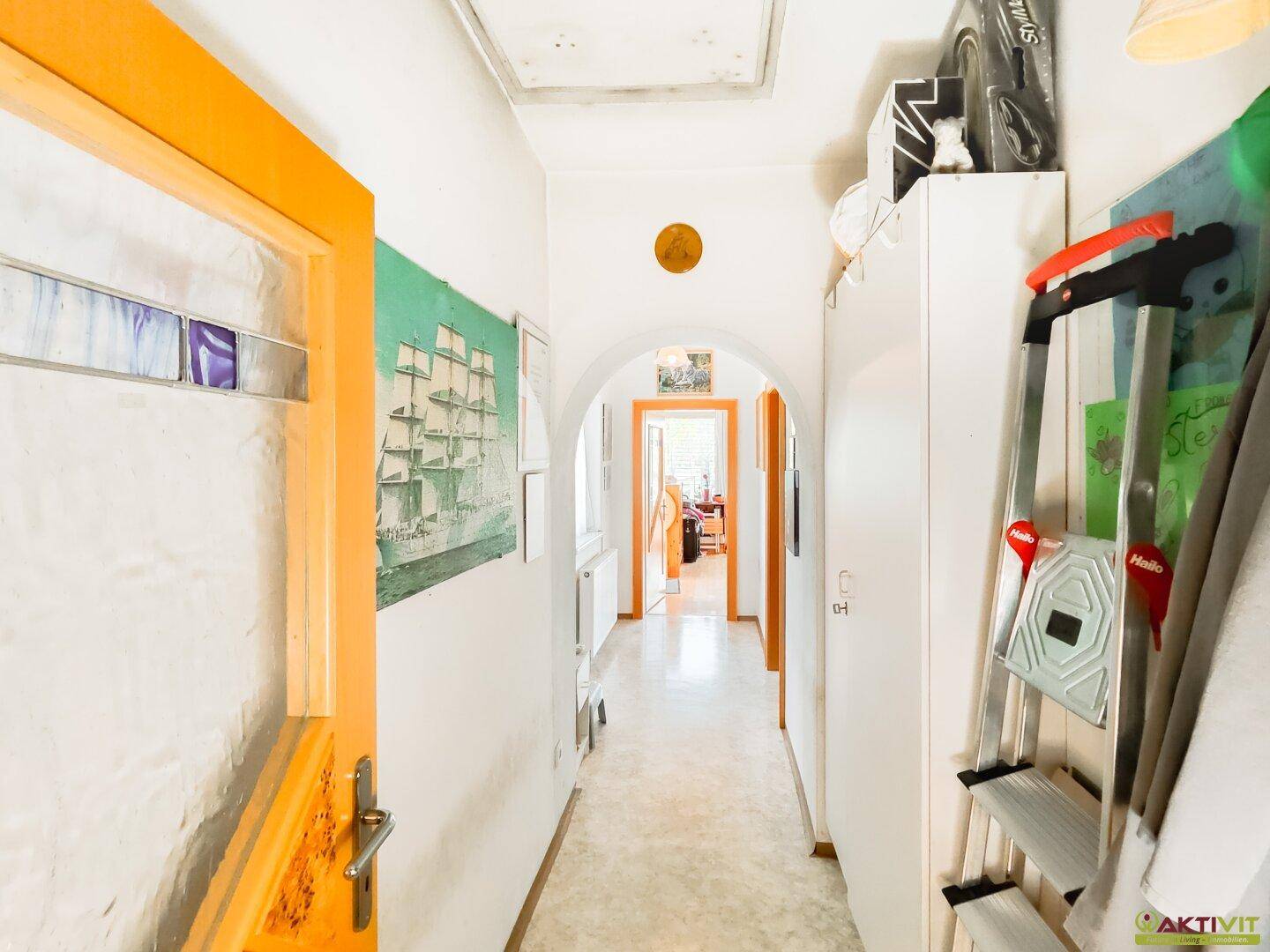Heller Flur mit Laminatboden und Durchgang zu weiteren Räumen, ausgestattet mit praktischen Möbeln.