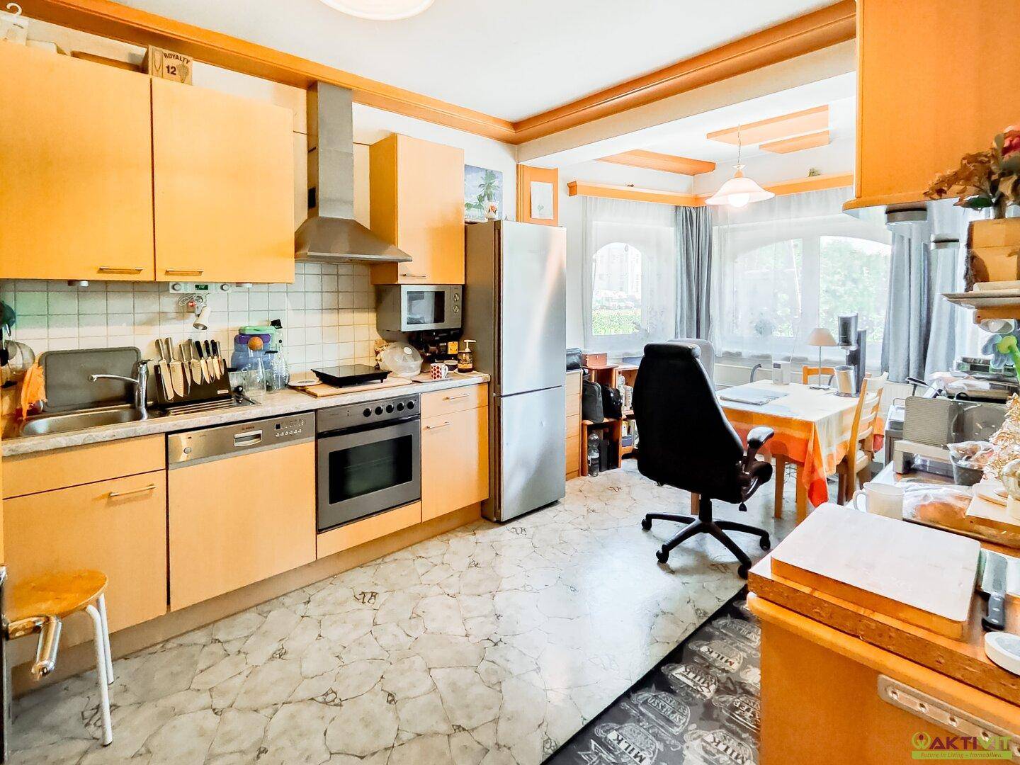 Geräumige Küche mit Essbereich, ausgestattet mit Holzschränken und modernen Geräten.