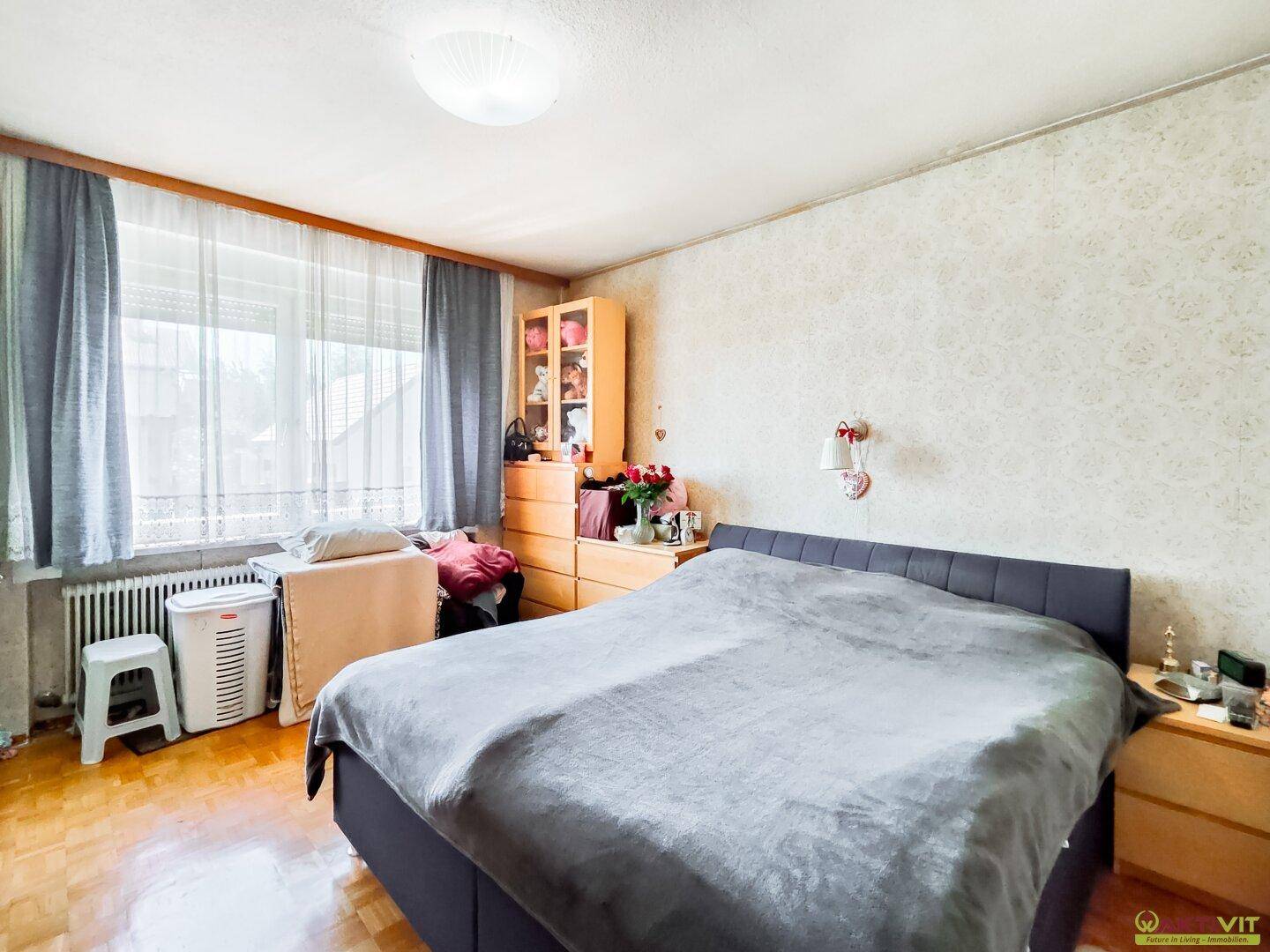 Schlafzimmer mit Doppelbett und Fenster, bietet eine ruhige und komfortable Rückzugsmöglichkeit.